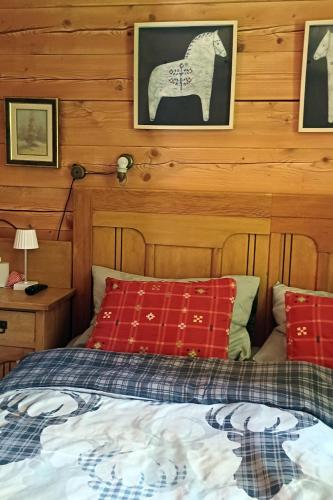 a bedroom with a bed with red pillows and a horse on the wall at Loghouse cabin in the Kočevje forest in Kočevje