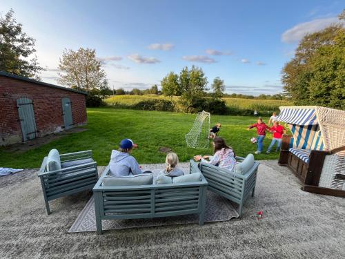 a group of people sitting on chairs in a backyard at Ferienwohnung Captains Lodge Steinbergkirche in Steinbergkirche