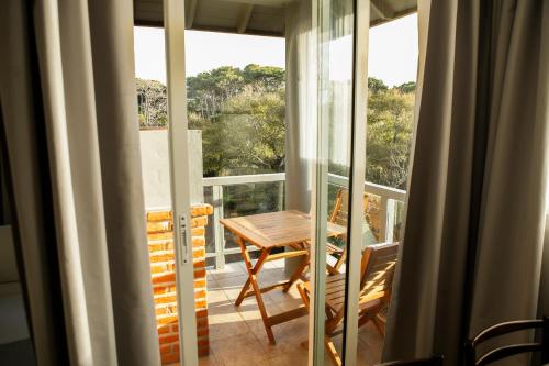 a balcony with a table and chairs and a window at Destinar Apart in Carilo