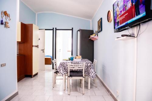 a dining room with a table and chairs and a tv at Casa Josto a due passi da Spiaggia Maladroxia in Maladroxia