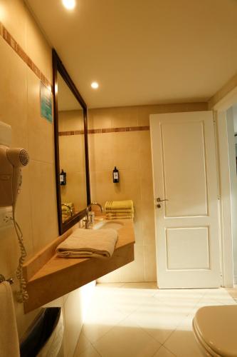 a bathroom with a sink and a mirror at Destinar Apart in Carilo