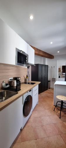 une cuisine avec des armoires blanches et un évier dans l'établissement Studio proche Capitole - Terrasse - Wifi - TV, à Toulouse