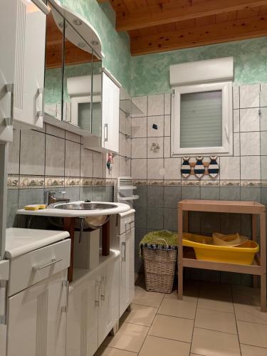 une cuisine avec des armoires blanches et un évier dans l'établissement maison a 400m de la mer, à Bretteville-sur-Ay