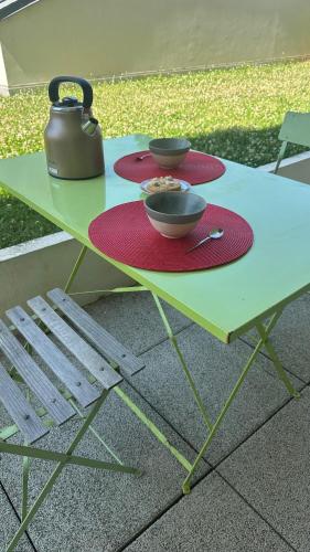 une table de pique-nique avec deux bols et une théière dessus dans l'établissement Nantes appartement plain pied proche Beaujoire, à Nantes