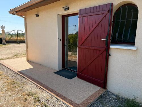 a red door on the side of a building at Le mas des anges in Soussans