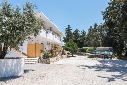 une grande maison blanche avec une allée dans l'établissement PaMar, à Faliraki