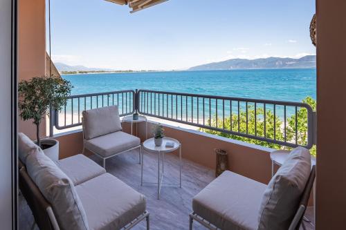 a balcony with chairs and a view of the ocean at Sea Flow - Luxury seafront Penthouse at Psani Beach in Nafpaktos