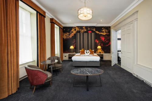 a hotel room with a bed and two chairs at Albany Hotel in Edinburgh
