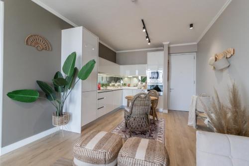 a kitchen with white cabinets and a table and chairs at Hospitality at Waterfall City - Ellipse Waterfall in Midrand