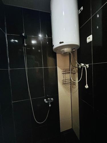 a shower in a bathroom with a white tank at Green Cottage in Ureki