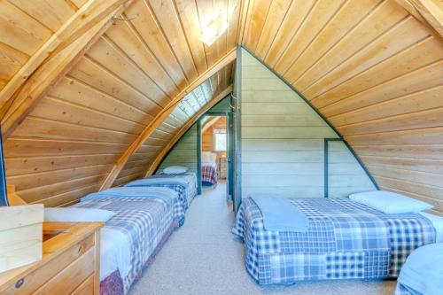 a room with three beds in a wooden attic at Blue Spruce Cabin in West Yellowstone