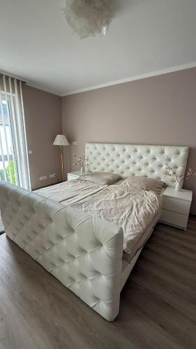 Traum-Ferienwohnung über 2 Etagen mit Sonnenterasse und Seenähe في زولبيتش: غرفة نوم مع سرير أبيض كبير مع اللوح الأمامي كبير