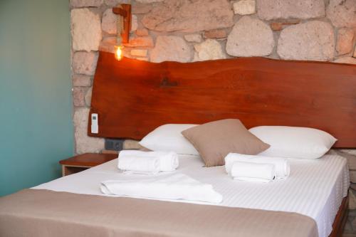 a bedroom with a bed with white sheets and pillows at Charming Stone Studio with Balcony & Breakfast-8 in Ayvalık