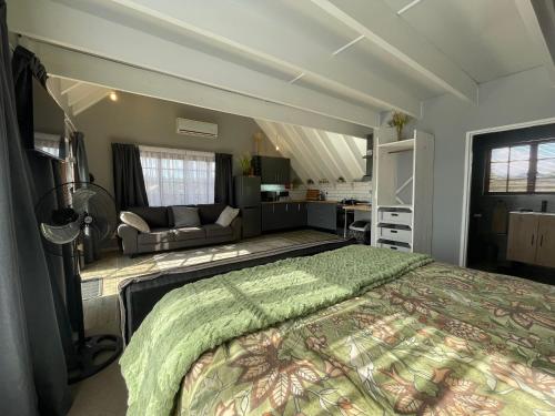 a bedroom with a large bed and a couch at ACORN STUDIO Fully equipped Studio with kids loft in Durban