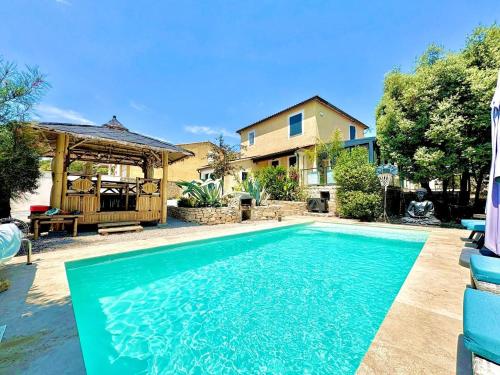 une piscine devant une maison dans l'établissement Villa Zénith - Piscine chauffée & Paillotte Bambou, à Nîmes