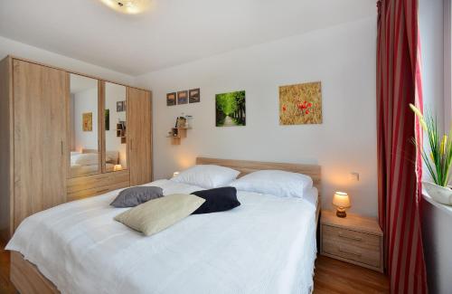 1 dormitorio con 1 cama blanca y 2 almohadas en Ferienwohnung Meeresblick, en Juliusruh