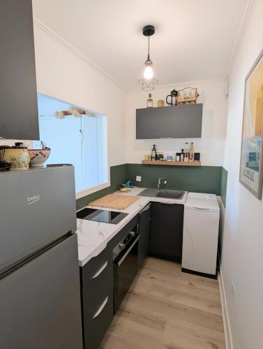 une cuisine avec un évier et un réfrigérateur dans l'établissement Studio 4 personnes - vue sur port du Pouliguen - Parking privé, linge fourni, au Pouliguen