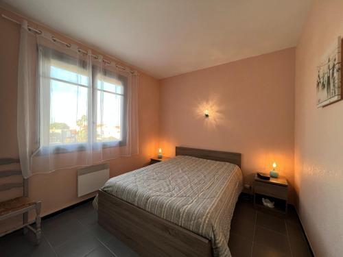 une chambre avec un lit et une fenêtre dans l'établissement T2 avec Balcon et Parking vue mer !, à Saint Cyprien Plage