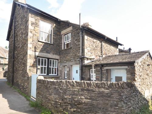 an old stone house with a stone wall at Cornerstones in Ambleside