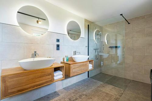 Un baño con dos lavabos y una ducha. en Country House Close To The Beach With Field Views, en Maasholm