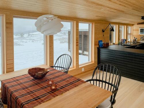 a kitchen and dining room with a table and chairs at Architect Drawn Holiday Home Near Rondane Park in Høvringen