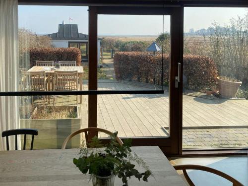 a room with a table and a view of a patio at Beach House With Sauna By Norsminde Harbour in Malling