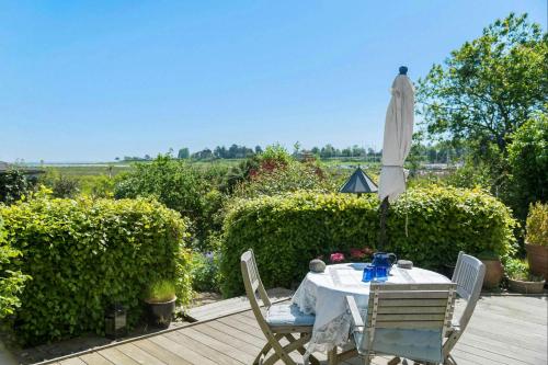 a table and an umbrella on a patio at Beach House With Sauna By Norsminde Harbour in Malling
