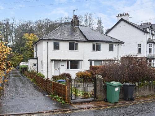 a white house with a fence in front of it at Tynedale in Keswick
