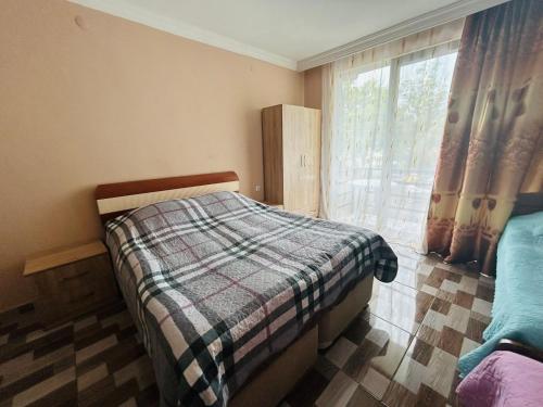 a bedroom with a bed and a window with curtains at Green Cottage in Ureki