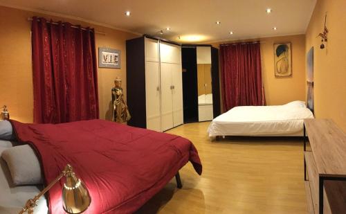 - une chambre avec 2 lits et des rideaux rouges dans l'établissement Villa privée Un vrai havre de paix, à Limoux
