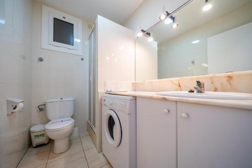 a bathroom with a sink and a washing machine at Apartaments Lamoga - Boabi in Torredembarra