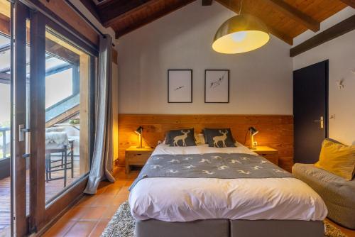 une chambre avec un lit et une grande fenêtre dans l'établissement Chaleureuse Fruitière – 8 personnes, à Samoëns