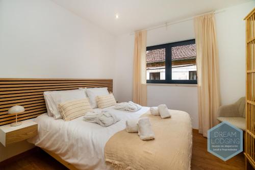 a bedroom with a bed with towels on it at Lagar da Vila - Dream Lodging in Avelar