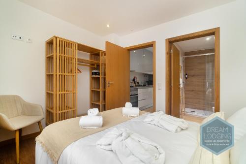a bedroom with a bed with towels on it at Lagar da Vila - Dream Lodging in Avelar