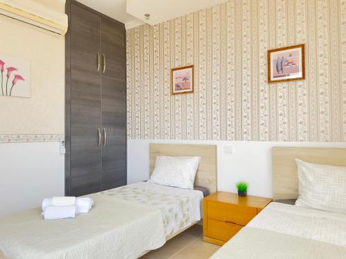 a bedroom with two beds and a wall at Near the sea Danaos 2 nice 2bd, 2bath sea view in Paphos City
