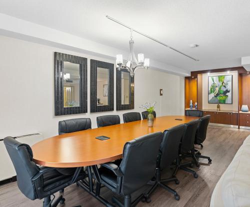 a conference room with a wooden table and chairs at Travelodge Hotel by Wyndham Saskatoon in Saskatoon