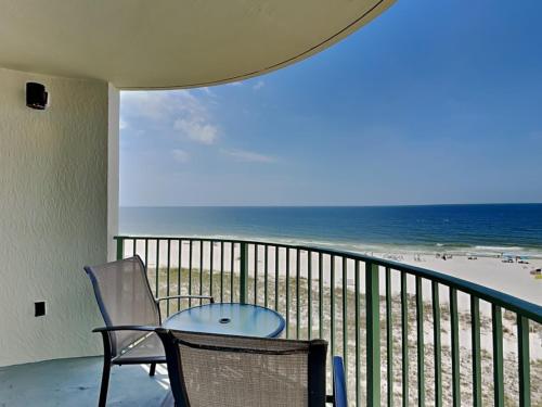 a balcony with a table and chairs and the beach at Perdido Towers #604 in Perdido Key
