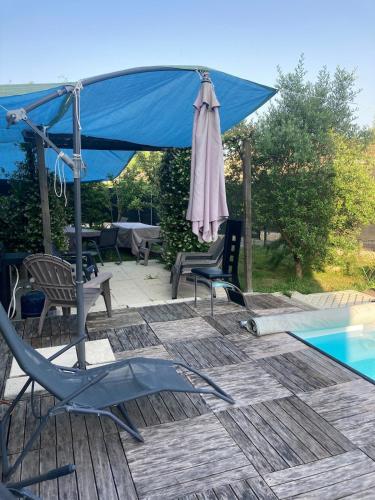 une terrasse avec un parasol, des chaises et une piscine dans l'établissement Maison pour 6 personnes avec jardin et piscine, à Artigues-près-Bordeaux