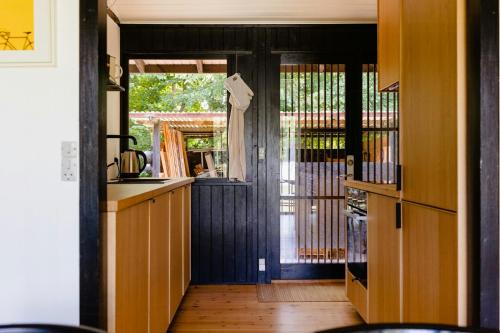 a kitchen with a door open to a yard at Birdsong And The Sound Of Waves At Reersø in Gørlev