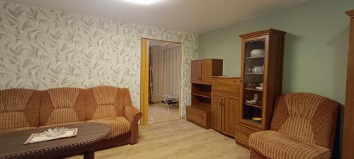 a living room with a couch and two chairs at Old Town apartment in Narva