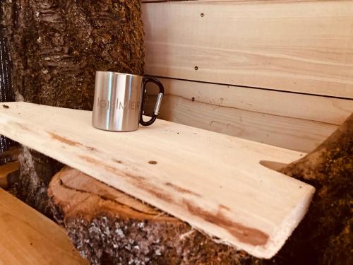 a metal cup sitting on top of a wooden shelf at Camping centra Shambhala in Lúčka