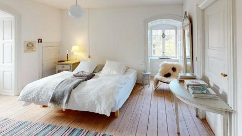 a bedroom with a bed with a dog sitting on it at Historic Atmosphere At Gelskov Estate For You in Ringe