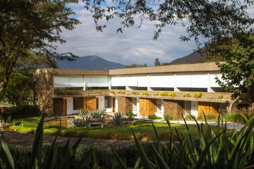 an exterior view of a building with mountains in the background at Tunas & Cabras Hotel in Ibarra