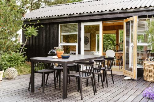 a patio with a table and chairs on a deck at Close To Beach, Forest And Bike Trails in Grenå