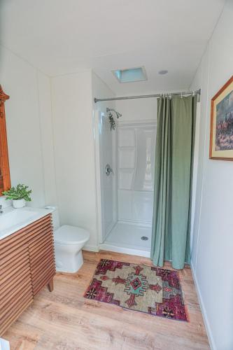 a bathroom with a toilet and a shower with a shower curtain at Highland Grand Canyon Glamping in Grand Canyon Village
