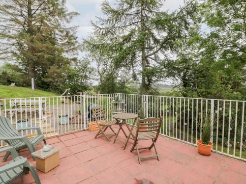 a patio with chairs and a table and a fence at The Barn in Dalbeattie