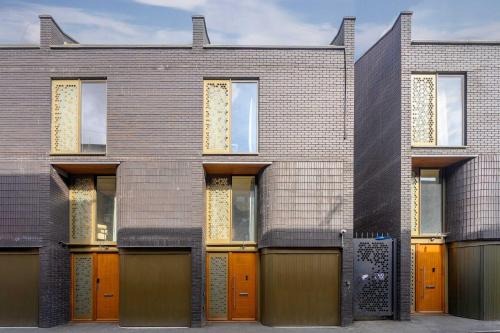 a brick building with orange doors and windows at Stunning Luxury Townhouse in Centre of Manchester in Manchester