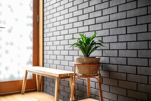 a potted plant sitting on a stool next to a table at Stunning Luxury Townhouse in Centre of Manchester in Manchester