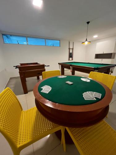eine Tischtennisplatte und Stühle in einem Zimmer in der Unterkunft Caribbean Blue - Jardim Oceania in João Pessoa