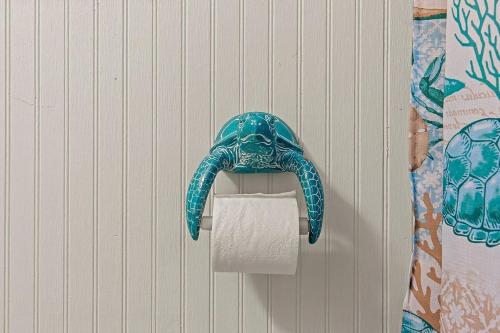 a dolphin shaped toilet paper holder on a wall at Casita Blanca- Charming Waterfront Home, Beach Club w Pool, 30' Dock in Key Colony Beach